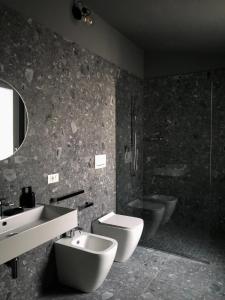 ein Badezimmer mit einem Waschbecken, einem WC und einer Badewanne in der Unterkunft whiterooms in Cesena