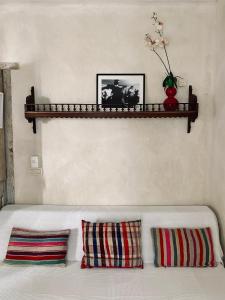 Sofá blanco con 2 almohadas y estante en la pared en Apartamentos Caravane, en Tarifa