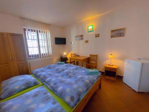 a bedroom with a bed and a table and a desk at Alva Pension 1 in Mikulov