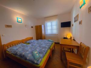 a small bedroom with a bed and a desk at Alva Pension 1 in Mikulov +30 photos