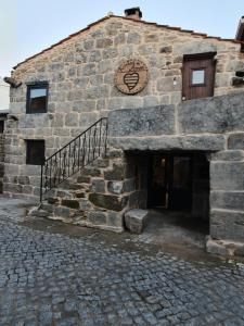 a stone building with a staircase in front of it at Fuinhas de Amor in Fornos de Algodres