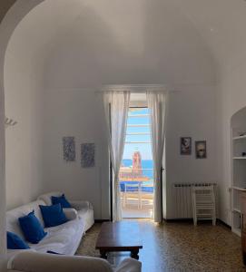 a living room with a couch and a large window at Amazing Apartment in Tellaro