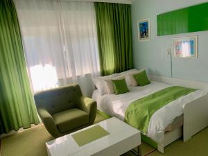 een kleine slaapkamer met een bed en een stoel bij City studio Maras terrace Marini dvori in Imotski