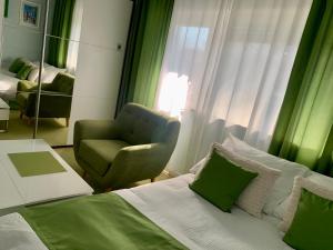 a bedroom with a bed and a chair and a mirror at City studio Maras terrace Marini dvori in Imotski