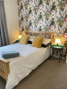 a bedroom with a large bed with a floral wallpaper at Maple House in Bristol