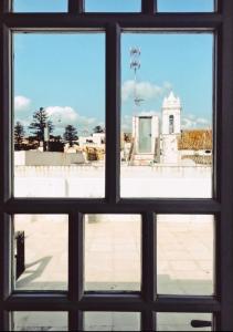 a view through a window looking out at a building at Apartamentos Caravane in Tarifa