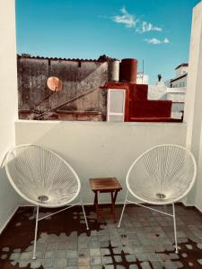 dos sillas blancas y una mesa en el techo en Apartamentos Caravane, en Tarifa