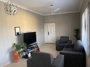 ein Wohnzimmer mit Sofas, einem TV und einem Sofa in der Unterkunft Captivating 2-Bed Ensuite Apartment in Accra in Accra