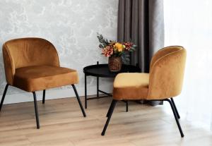 dwa krzesła i stół z wazonem kwiatów w obiekcie Patio Riverfront Aparthotel w Gdańsku