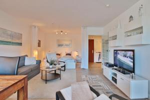 a living room with a couch and a tv at Hanseat am Hang 3 - 5 Strandhafer Appartement 5 in Scharbeutz