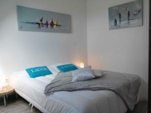 a bed in a bedroom with two pictures on the wall at La marine D'opale in Ambleteuse +194 photos