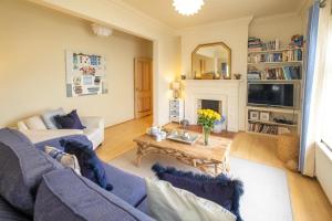 奧爾德堡的住宿－The Old Bakery - Aldeburgh Coastal Cottages，客厅配有蓝色的沙发和桌子