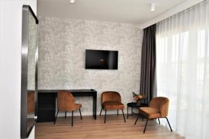 a living room with three chairs and a fireplace at Patio Riverfront Aparthotel in Gdańsk