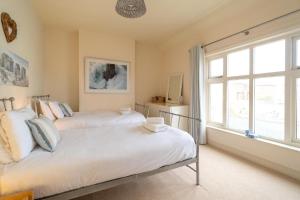 two beds in a room with a window at The Old Bakery - Aldeburgh Coastal Cottages in Aldeburgh