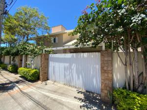 a white fence in front of a house at Pousada Altas Natureza in Florianópolis