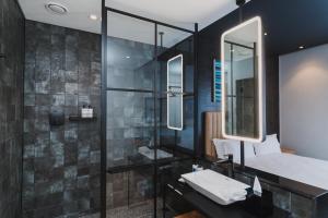 a bathroom with a shower and a sink and mirror at Century City Hotel Bridgewater in Cape Town +18 photos