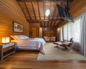 a bedroom with a bed and a tv in it at Aires de Patagonia in Cambara do Sul