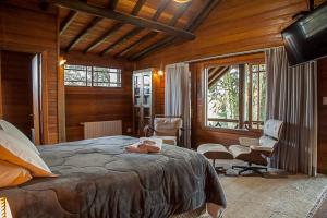 a bedroom with a bed and chairs in a room at Aires de Patagonia in Cambara do Sul