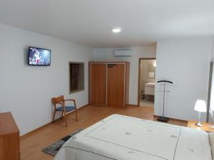 - une chambre avec un lit, une table et une chaise dans l'établissement Casa Novelhos, à Penafiel