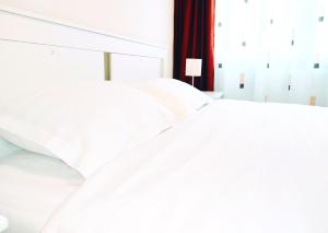 Duas almofadas brancas em cima de uma cama em Smart Apartament em Piatra Neamţ