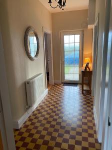 um corredor com um piso xadrez e um espelho em Pat's Cottage em Kinawley