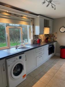 a kitchen with a washing machine and a sink at Pat's Cottage in Kinawley