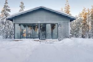 uma pequena casa na neve na floresta em Villa Karhukoto Ruka em Kuusamo