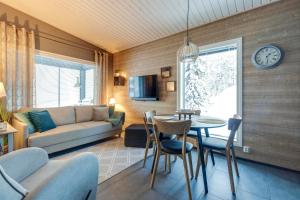 ein Wohnzimmer mit einem Sofa und einem Tisch in der Unterkunft Villa Karhukoto Ruka in Kuusamo