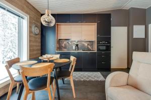 a kitchen and dining room with a table and chairs at Villa Karhukoto Ruka in Kuusamo