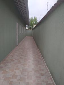 a hallway with a tiled floor next to a building at Linda casa ! in Mongaguá