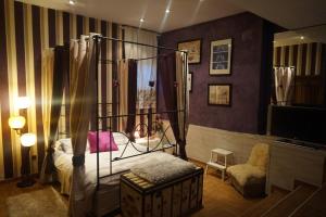 uma sala com um quarto com uma cama de dossel e uma televisão em Lantica roccia em Manzanares el Real