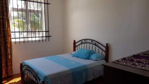 ein Schlafzimmer mit einem Bett mit einem blauen Kissen darauf in der Unterkunft Soleil Couchant No 2 in Flic-en-Flac