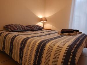 - une chambre dotée d'un lit avec deux oreillers et une lampe dans l'établissement Brive Centre, à Brive-la-Gaillarde