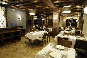 a restaurant with white tables and chairs in a room at Hotel Veneto De Vigan in Vigan