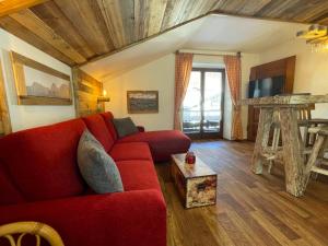 a living room with a red couch and a table at Thannheimer Häusl in Oberstdorf