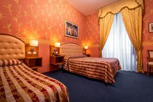 a hotel room with two beds and two lamps at Hotel Villa Romeo in Catania