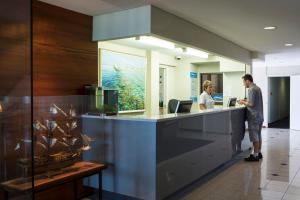 a man and a woman standing at a counter at Ocean Centre Hotel in Geraldton