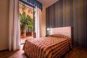 a bedroom with a large bed and a large window at Hotel Villa Romeo in Catania