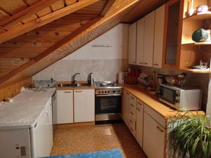 a kitchen with white cabinets and a stove top oven at Tourist Farm Strle With Great Local Food in Cerknica