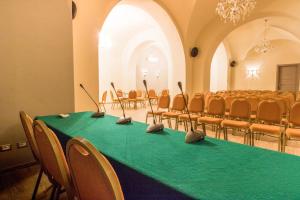 a conference room with a green table and chairs at Hotel Villa Romeo in Catania