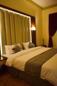ジッダにあるشقق وأجنحة التيوليب والروز وود الفاخرةのベッドルーム1室(大型ベッド1台、白いシーツ、枕付)