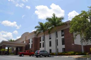 a red truck parked in front of a building at Days Inn & Suites by Wyndham Fort Myers Near JetBlue Park in Fort Myers