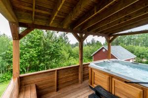 a hot tub on a wooden deck with a roof at Le Relais de la Martine in Petite-Rivière-Saint-François