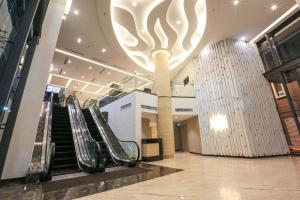 eine Lobby mit Rolltreppen und einer großen Leuchtvorrichtung in der Unterkunft Eco Tree Hotel, Melaka in Malakka