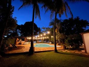 einen Pool in der Nacht mit Palmen und Lichtern in der Unterkunft Casa do Lago Hospedaria in Brasilia