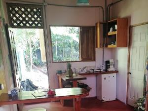 a kitchen with a table and a large window at Casa Arlecchino in Puerto Viejo