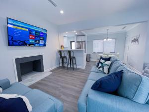 uma sala de estar com um sofá azul e uma televisão de ecrã plano em Great Stay in South Florida! -D-Centrally located em Miami