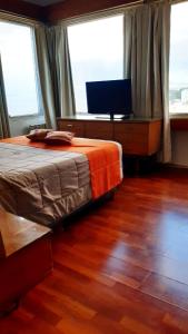 a bedroom with a bed and a desk and two windows at Lo de Ramón in San Carlos de Bariloche +33 photos