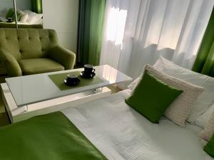 a bedroom with a bed with a coffee table and a chair at City apartment Mara’s terrace - Marini dvori / 4 pax in Imotski