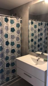 baño con lavabo y cortina de ducha en Cómodo apartamento frente al Mar, en Piriápolis
